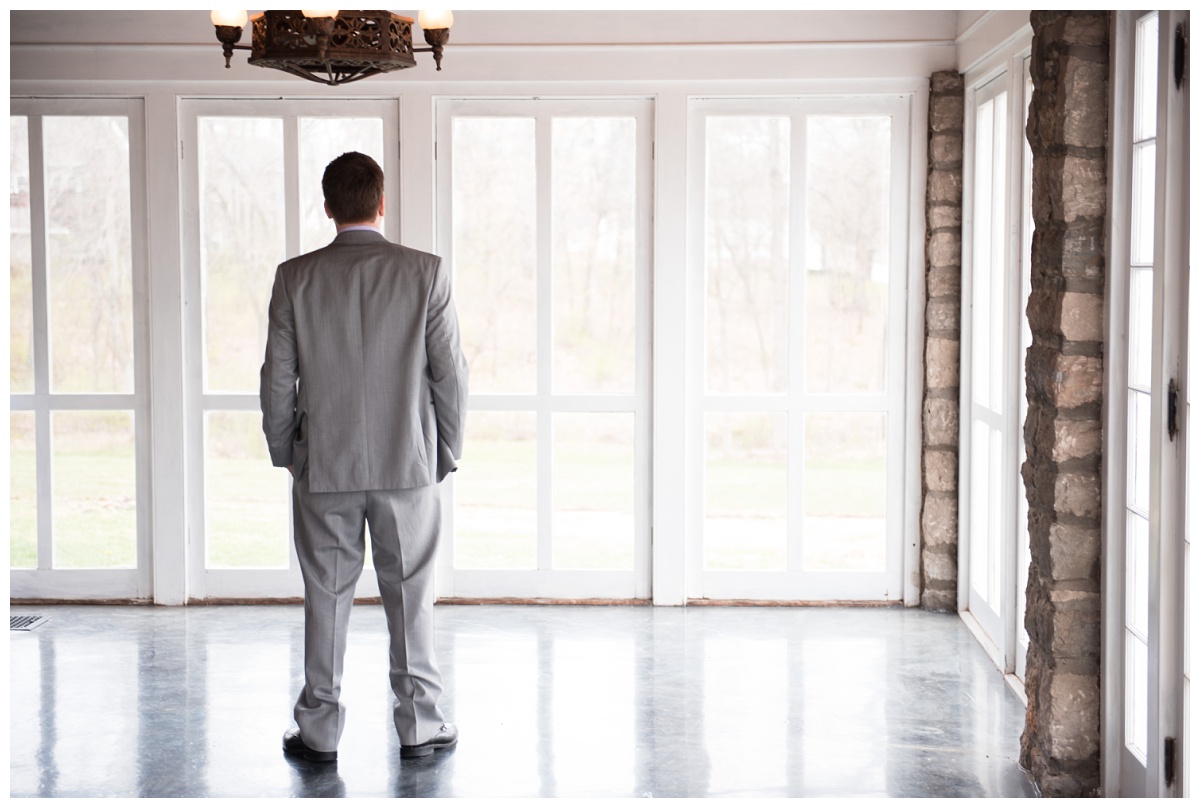 Groom in grey suit waiting to see his bride at Stone House of St Charles, a St Louis wedding venue