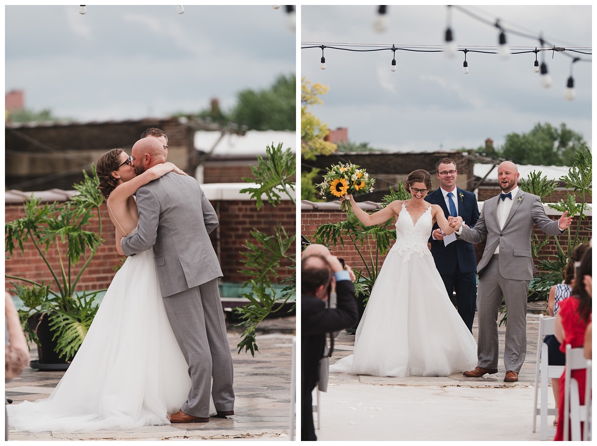 Bride and groom sharing first kiss at rooftop wedding ceremony at Jefferson Underground | Bride and groom being introduced as man and wife, arms both raised in celebration. 